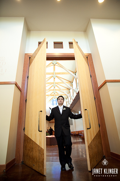 Filipino American Groom exits stately wood doors at St Vincent De Paul in Federal Way WA