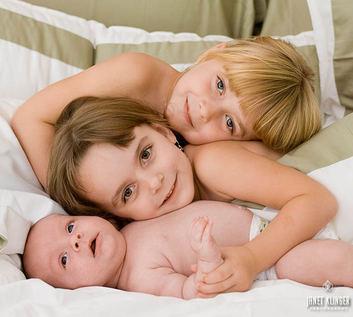 Janet Klinger_ Sisters snuggle a newborn baby brother